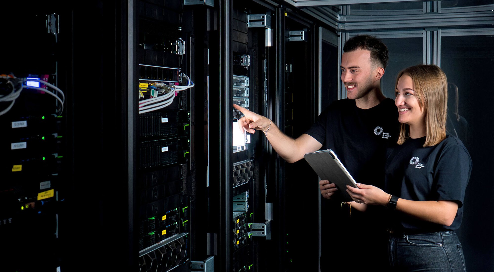 Zwei IT-Fachkräfte der Wilken Software Group arbeiten im Rechenzentrum in Ulm und prüfen Server- und Systeminfrastruktur. Sie stehen vor modernen Serverschränken, analysieren Hardwarekomponenten und stimmen Maßnahmen für den zuverlässigen Betrieb digitaler Lösungen ab.